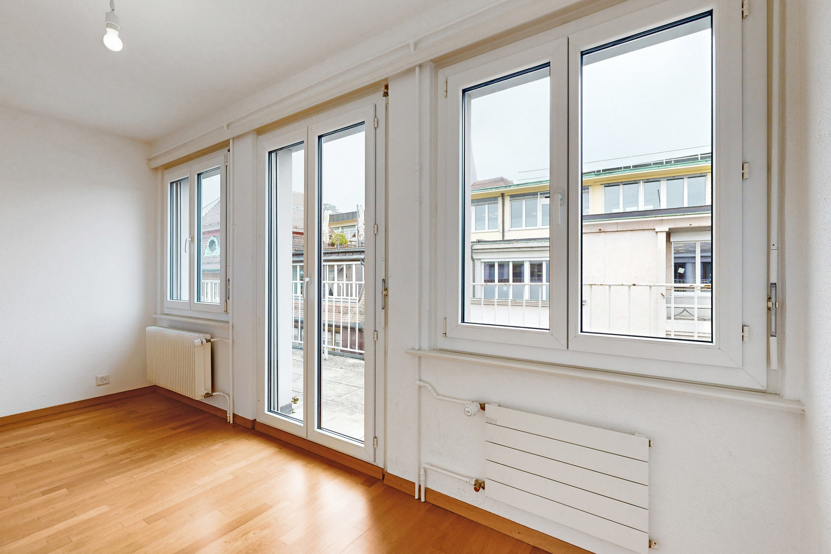Heller leerer Wohnraum mit großem Fenster- und Türbereich