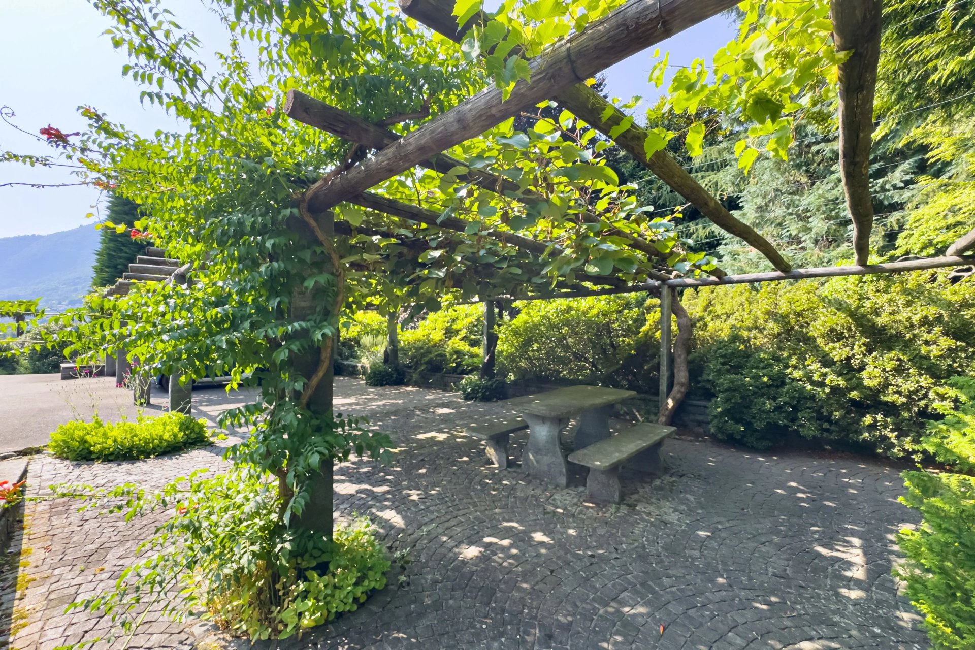 Überdachte Gartenlaube mit Sitzgruppe