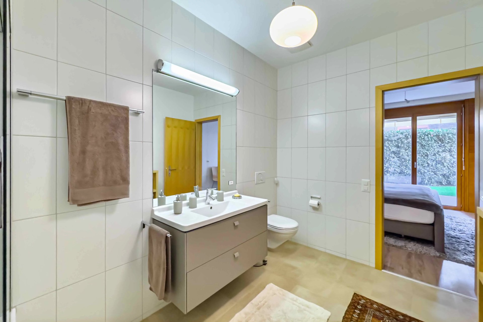 Modernes Badezimmer mit Blick ins angrenzende Schlafzimmer