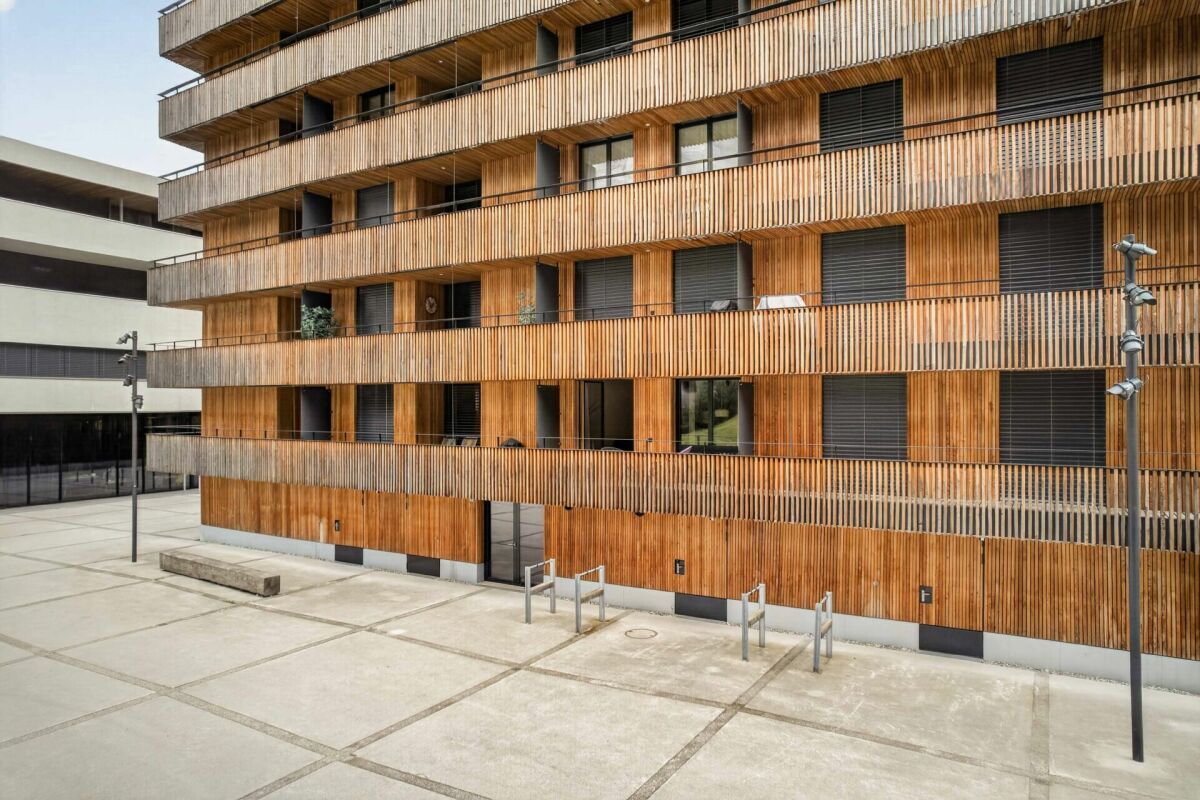Modernes Wohngebäude mit Holzfassade und Balkonen