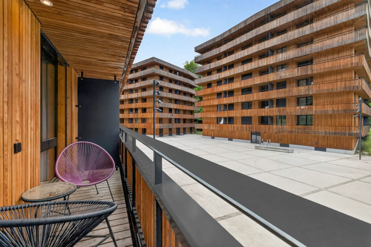 Balkon mit Holzkonstruktion und Blick auf moderne Wohngebäude