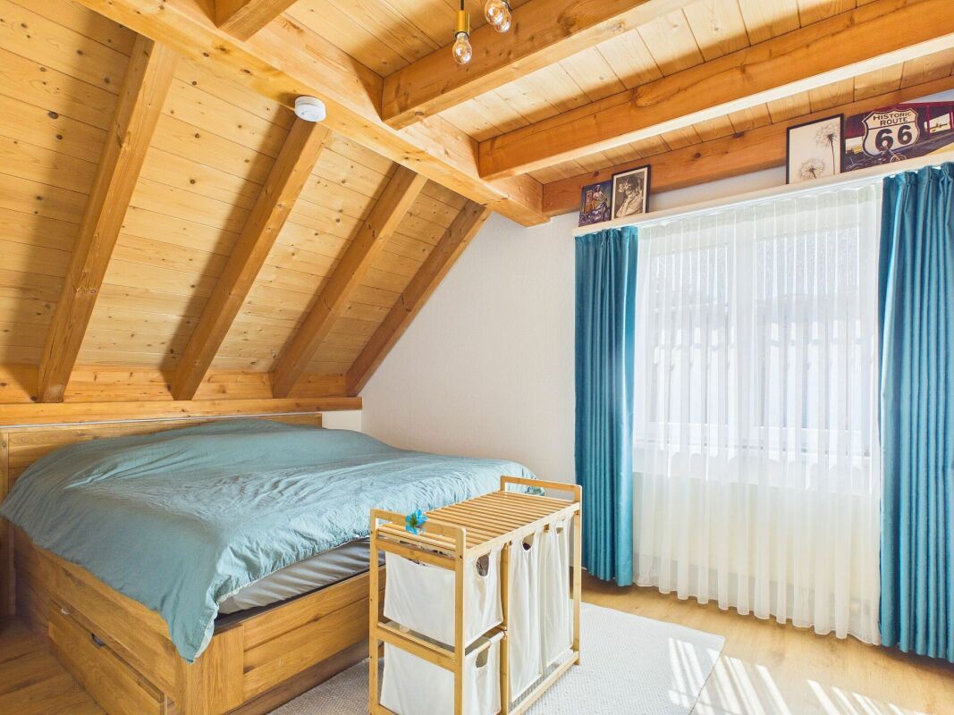 Dachgeschoss-Schlafzimmer mit Holzbalkendecke