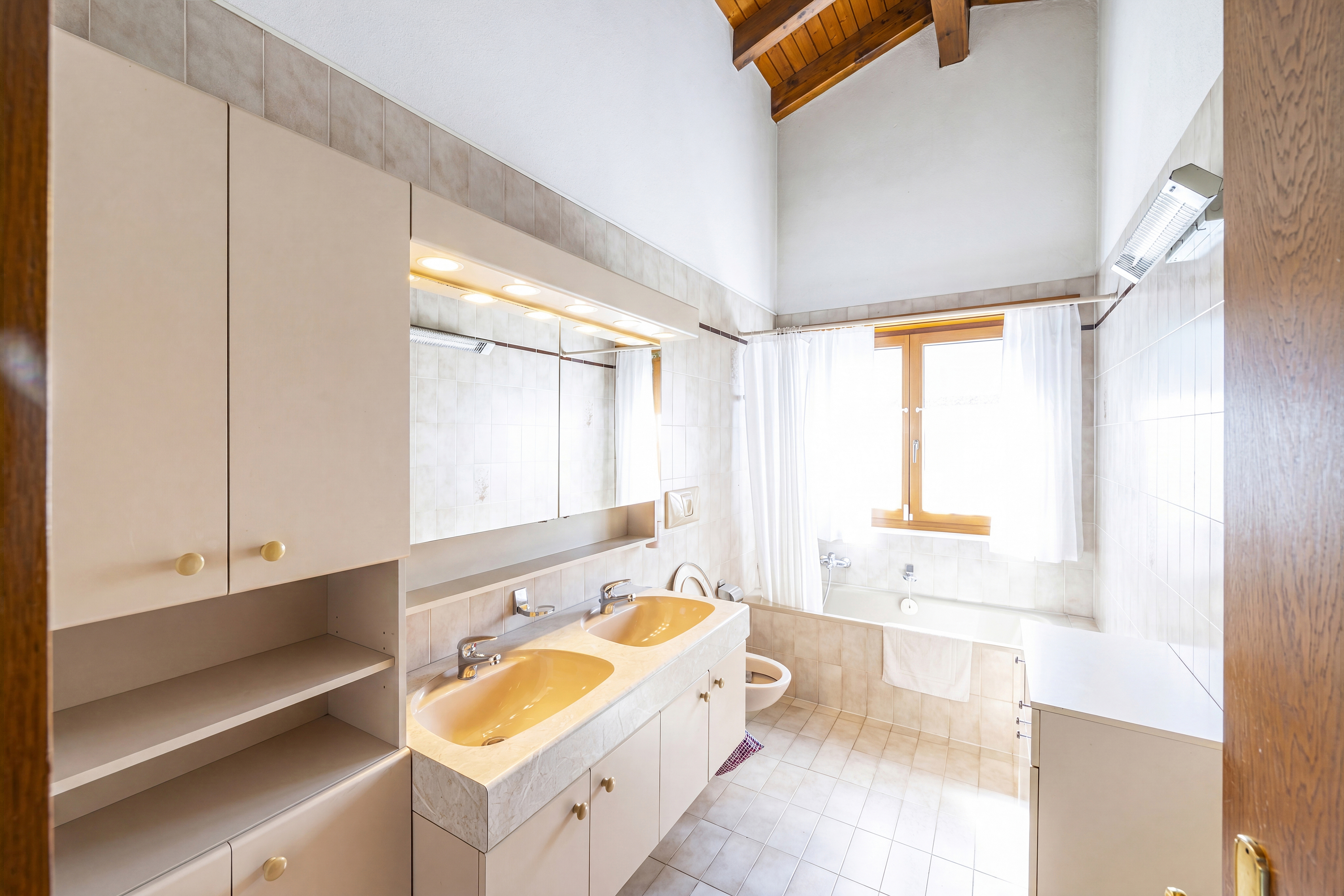 Helles Badezimmer mit Badewanne und Doppelwaschtisch