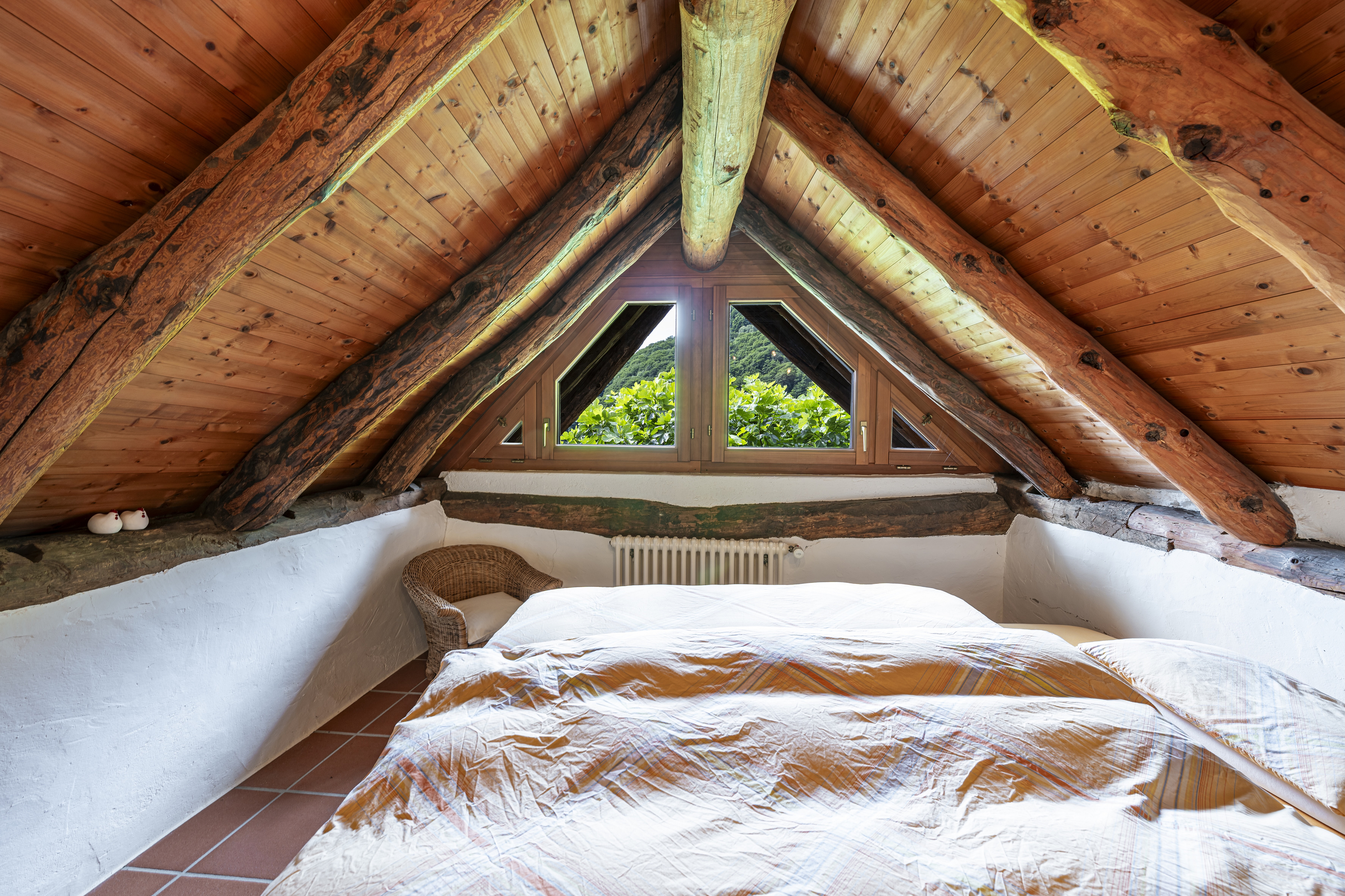 Gemütliches Dachgeschoss-Schlafzimmer mit Holzsichtdachstuhl