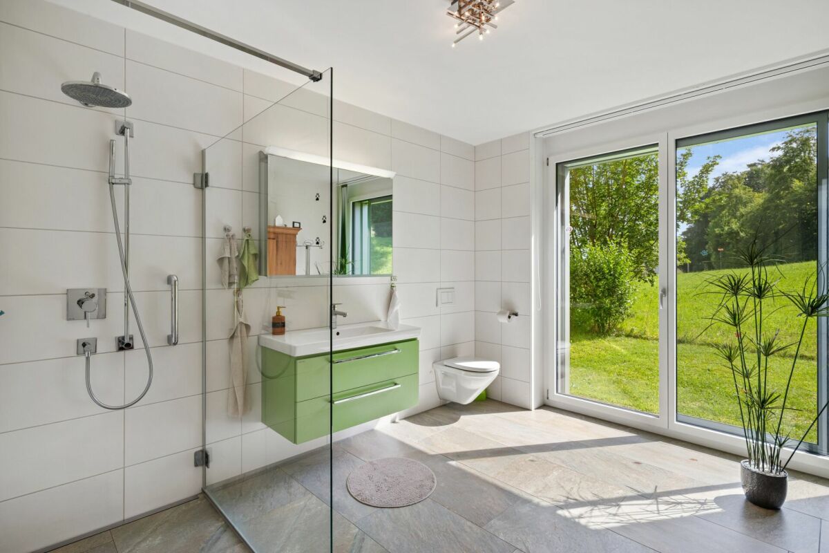 Modernes Badezimmer mit Glasdusche und Gartenblick