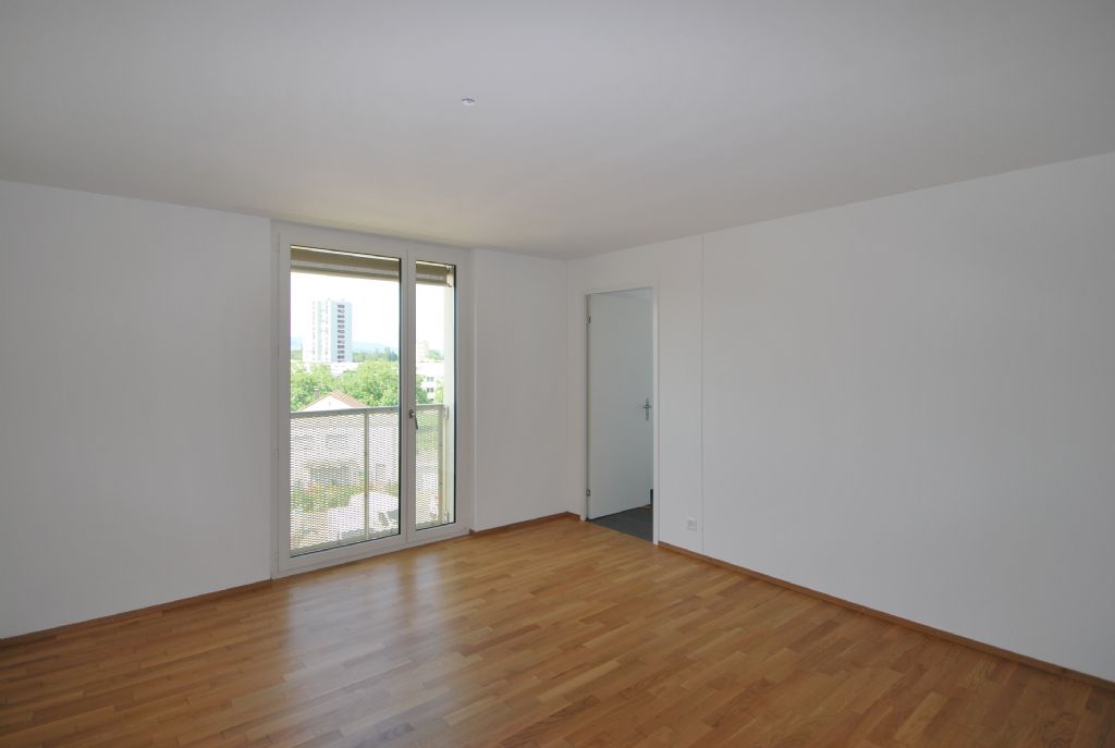 Heller leerer Wohnraum mit Balkon und Blick ins Freie