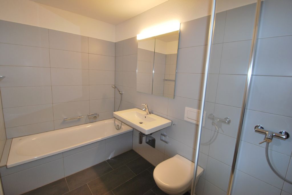 Modernes Badezimmer mit Badewanne, Waschtisch und Dusche