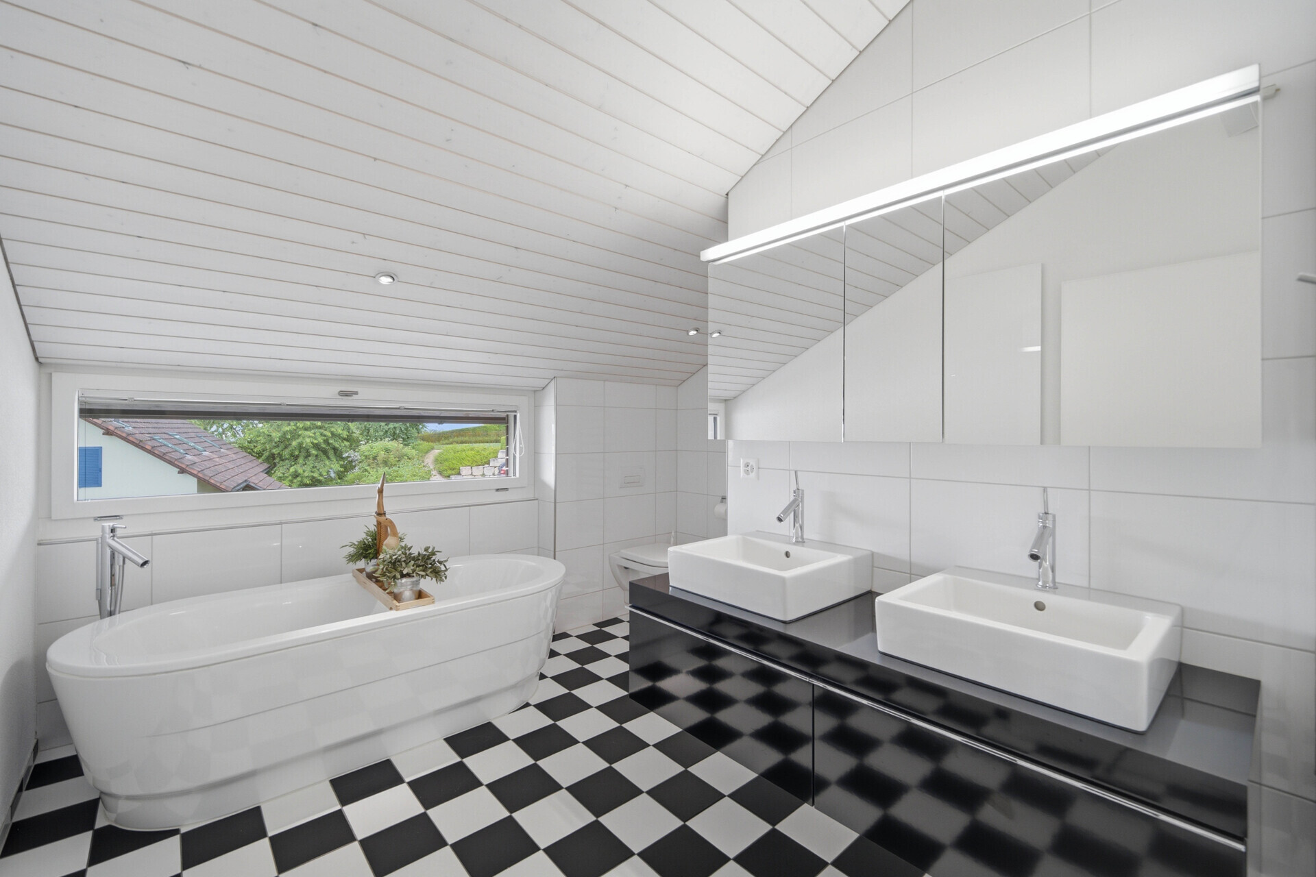 Modernes Badezimmer mit Dachschräge und freistehender Wanne