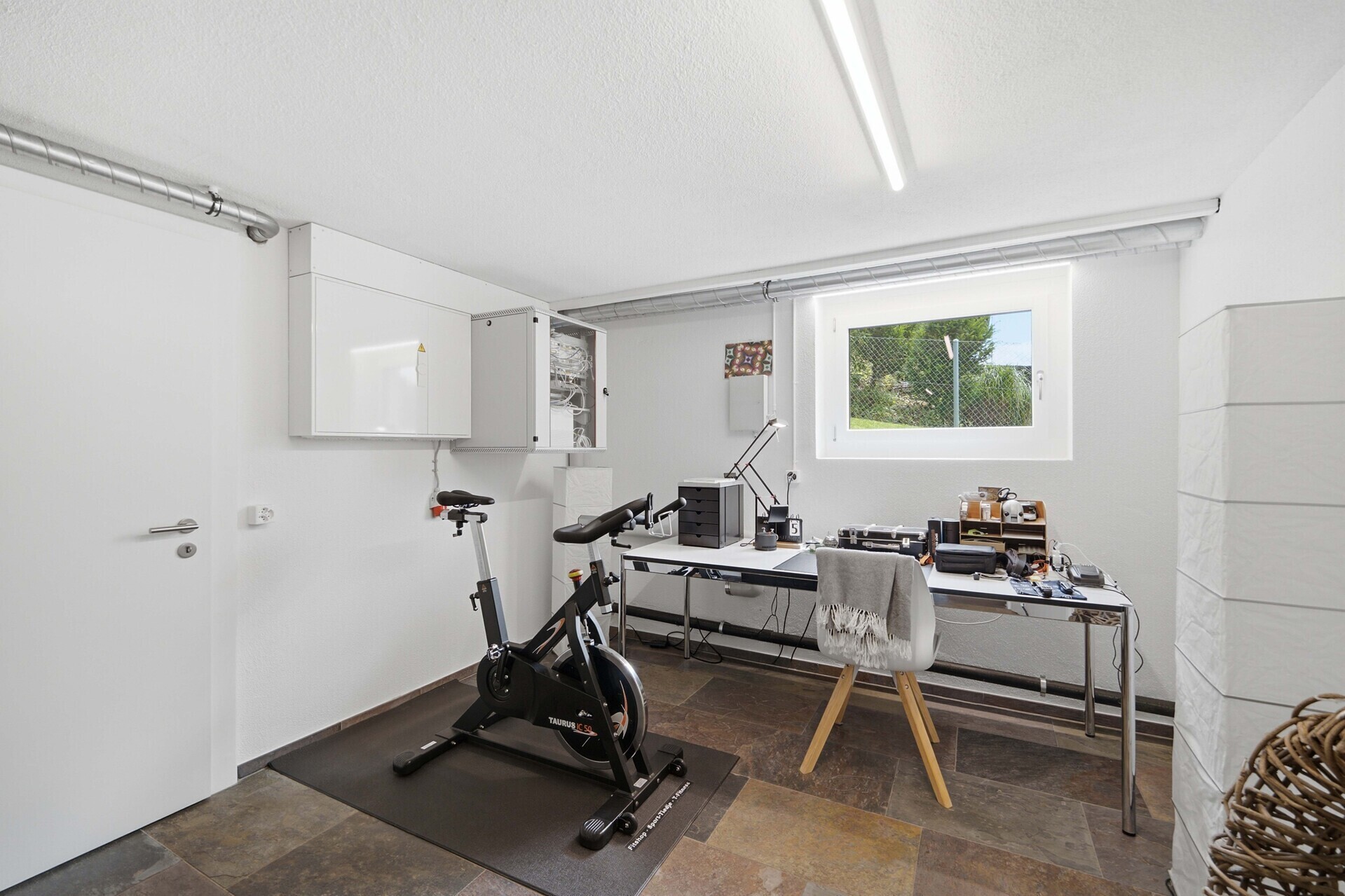 Heller Hauswirtschafts- bzw. Technikraum mit Fitnessbereich