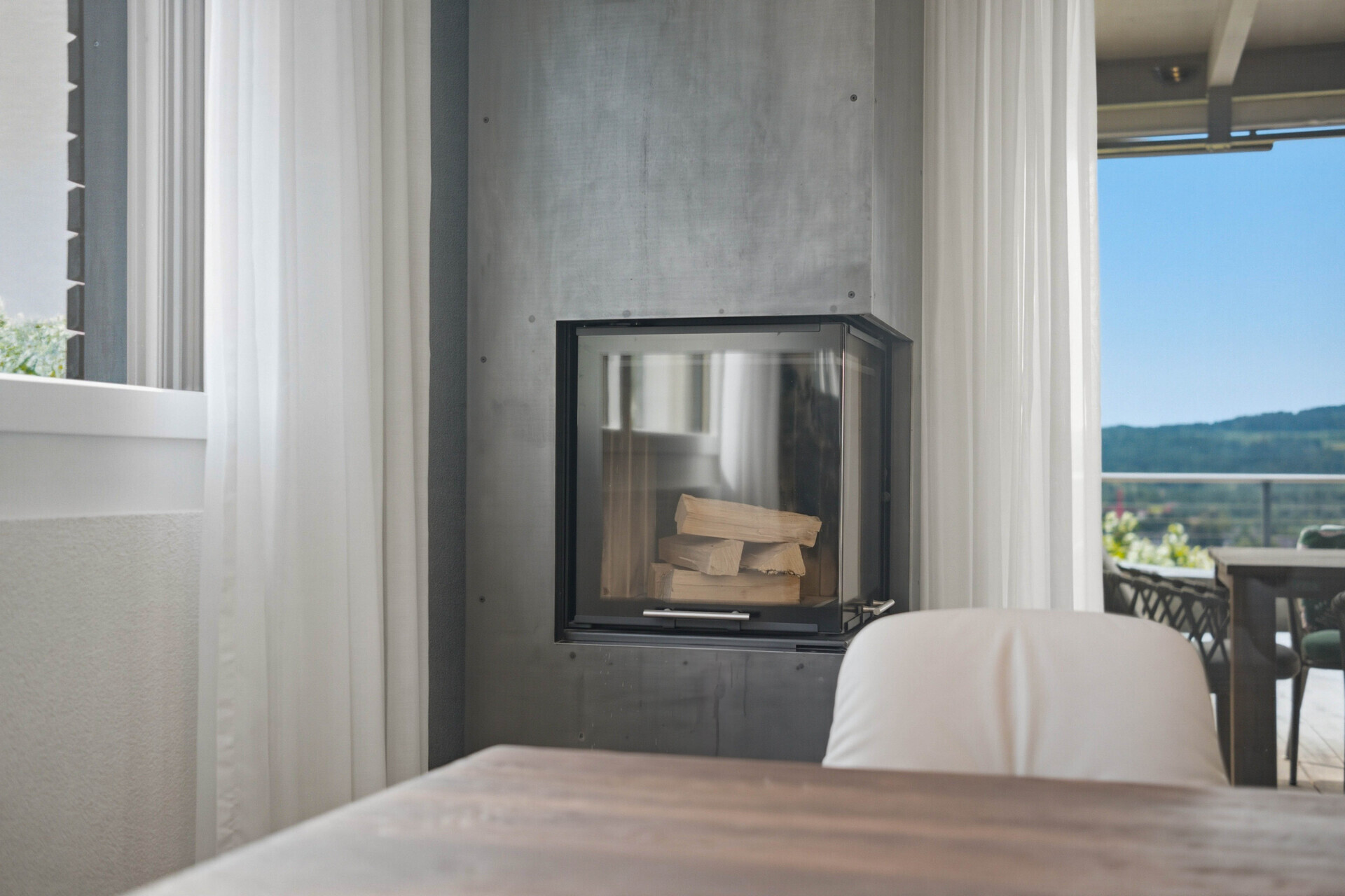 Wohnbereich mit Kamin und Terrassenblick