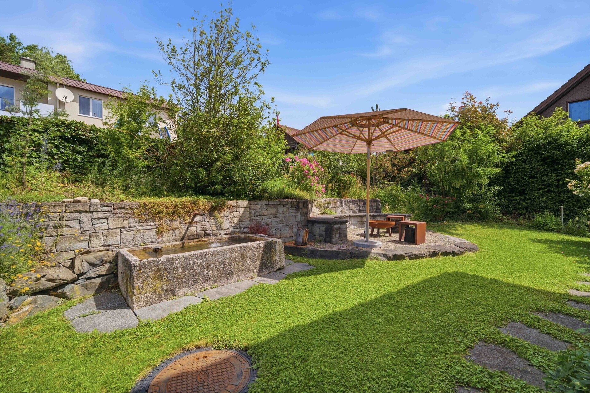 Gepflegter Garten mit Sitzbereich und Wasserbecken