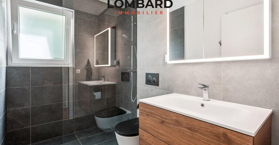 Modernes Badezimmer mit grauen Fliesen und Holzwaschtisch
