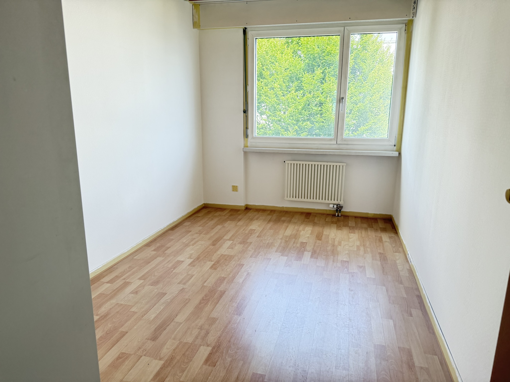 Leerer kleiner Raum mit Fenster und Heizkörper