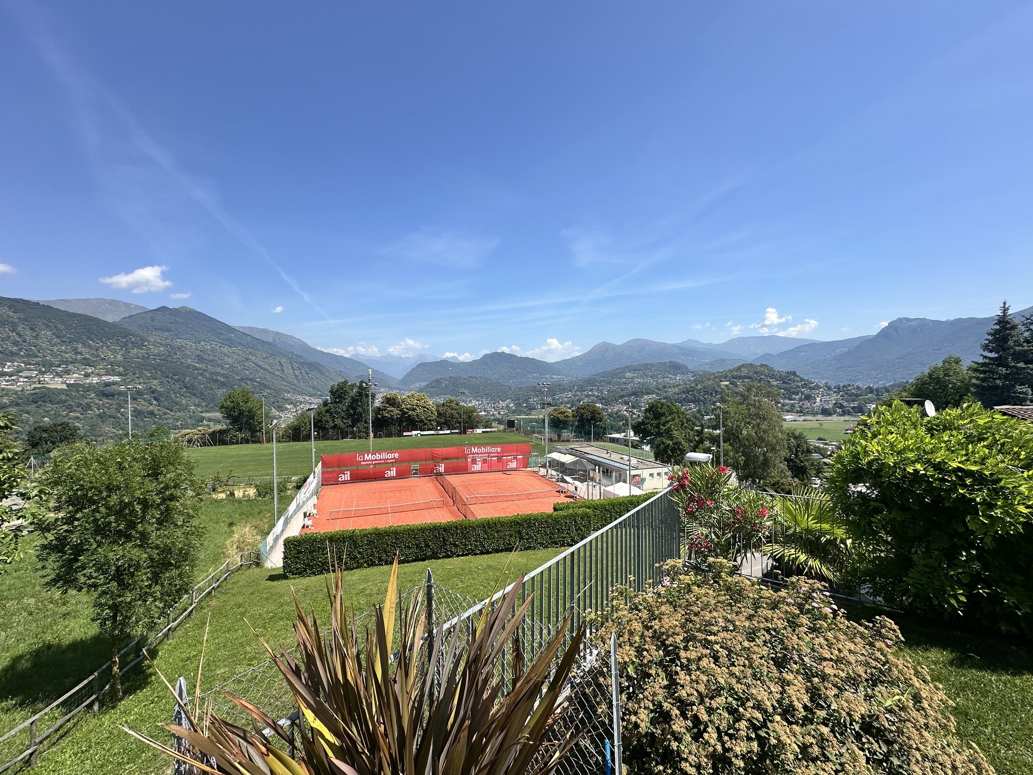 Weitblick über Tennisplätze und Berge