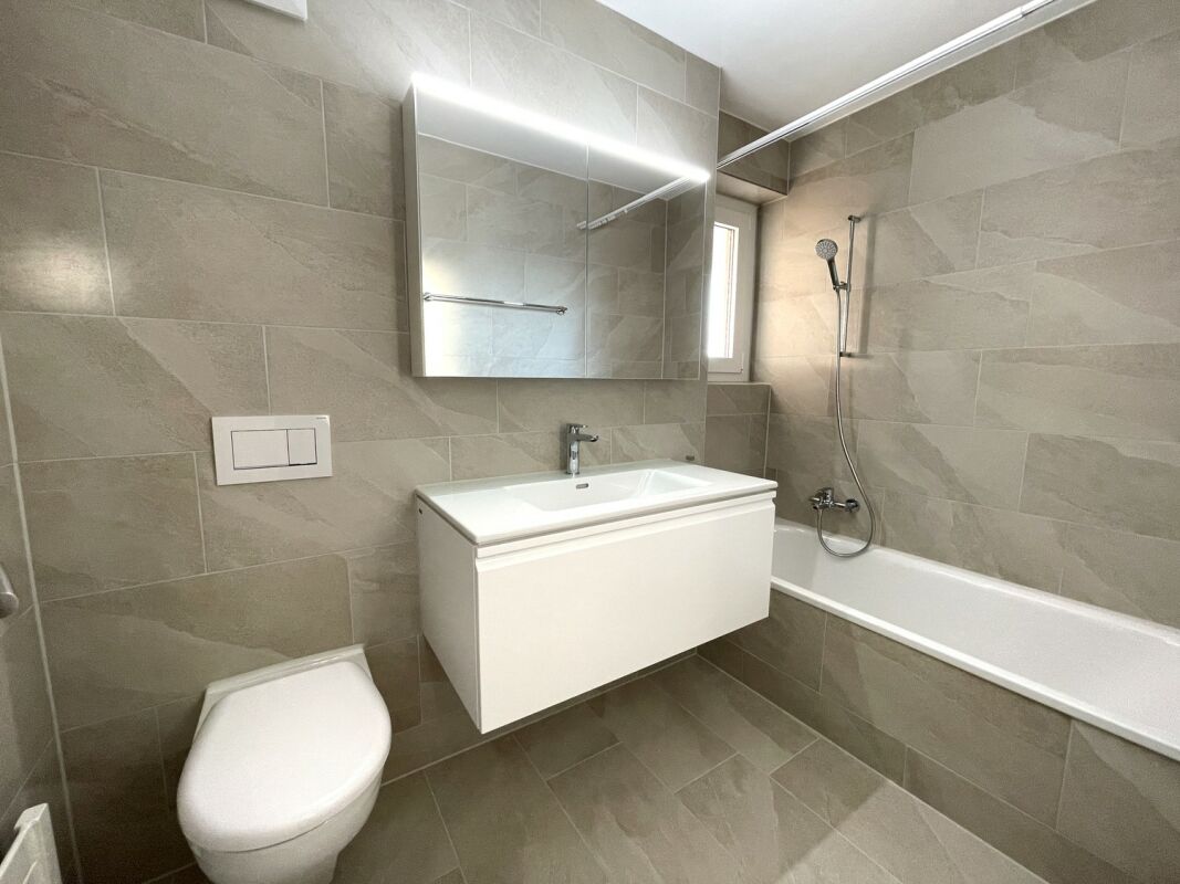 Modernes Badezimmer mit Badewanne und Wand-WC