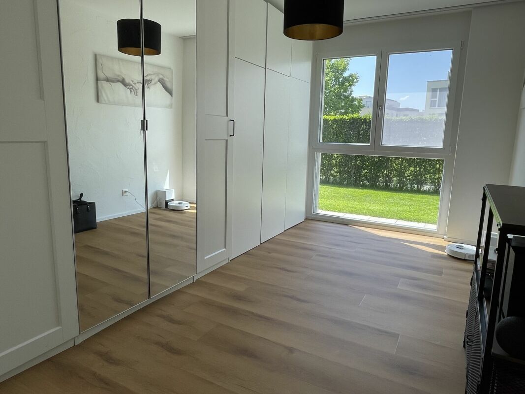 Helles Schlafzimmer mit Einbauschrank und Gartenblick