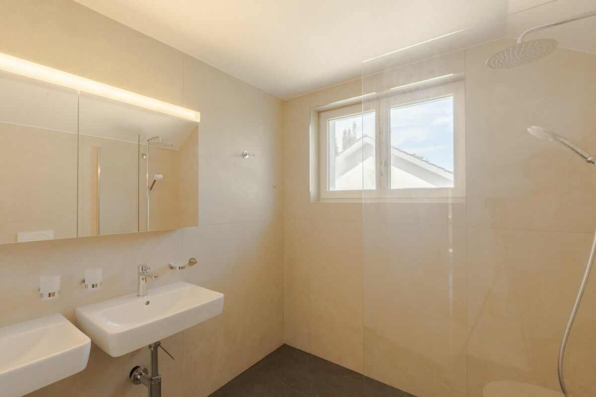 Modernes Badezimmer mit Doppelwaschbecken und Fenster