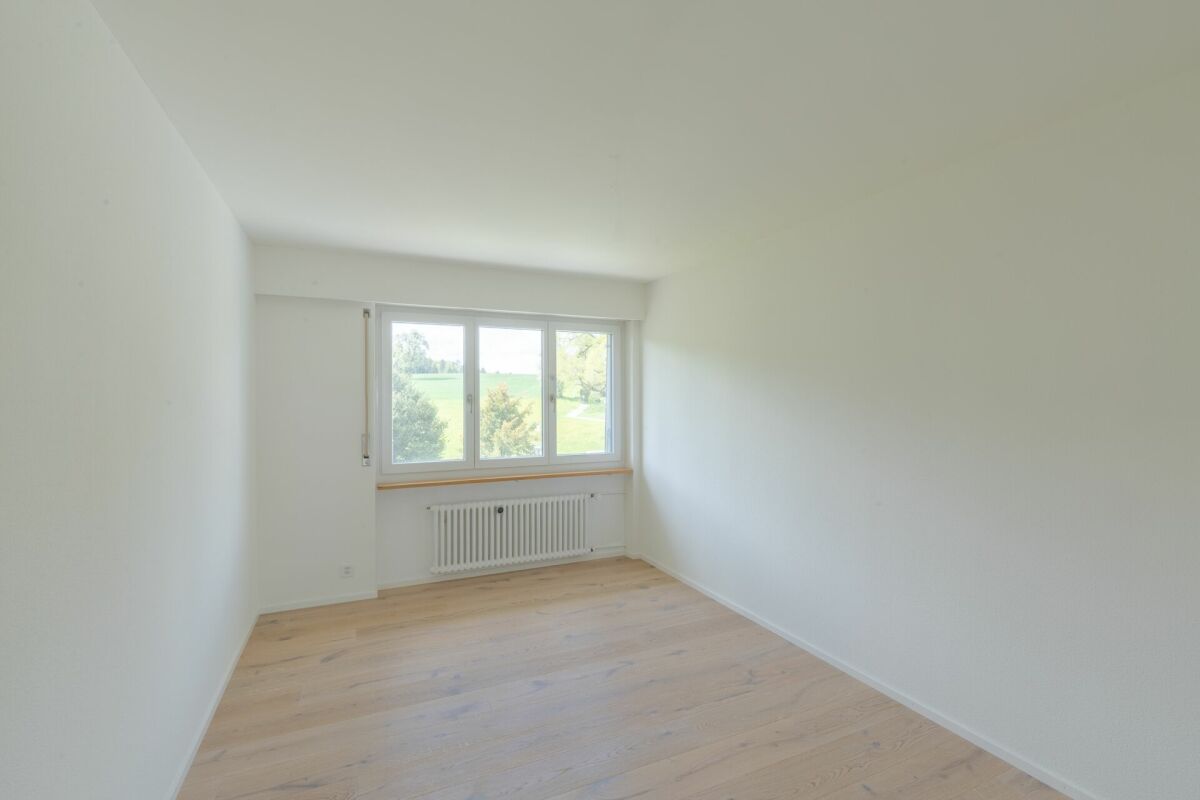 Helles leeres Zimmer mit Fenster und Heizkörper