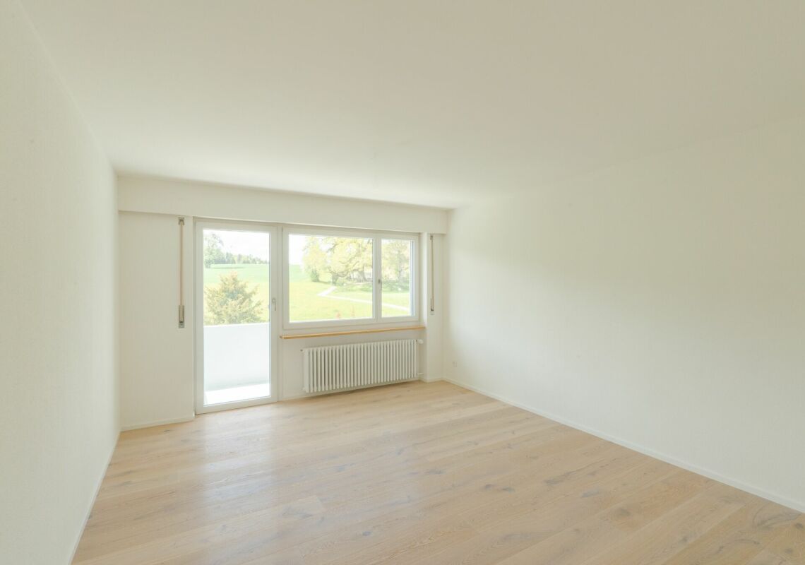 Helles, leeres Zimmer mit Balkon und Blick ins Grüne
