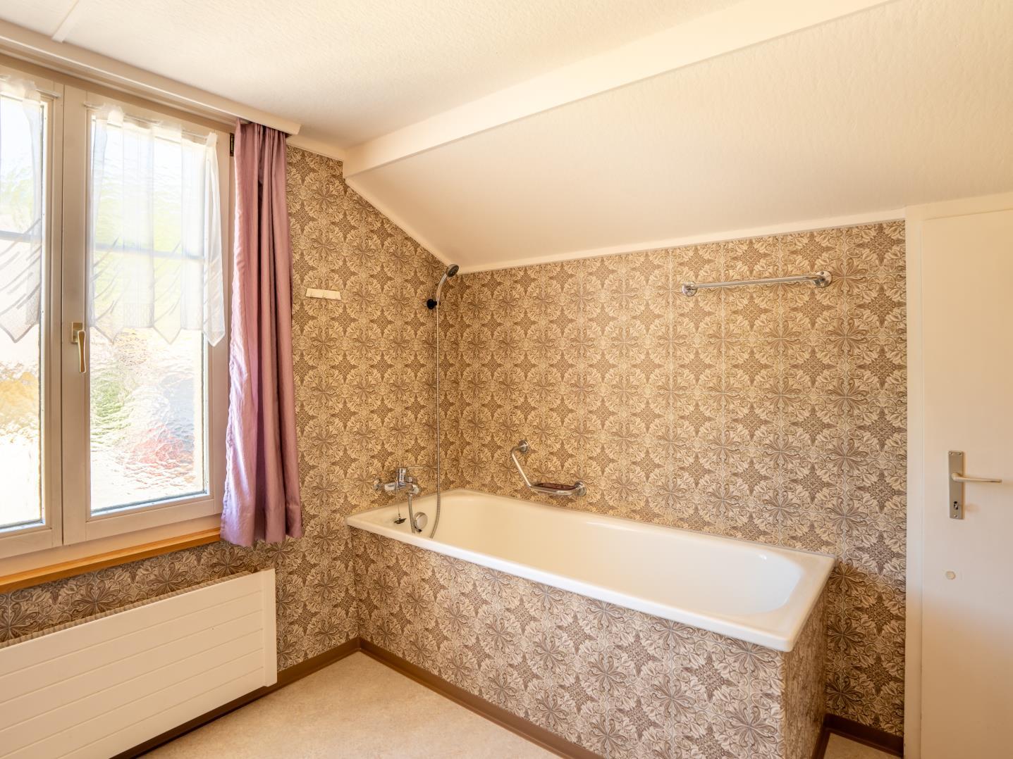 Badezimmer mit Badewanne unter Dachschräge