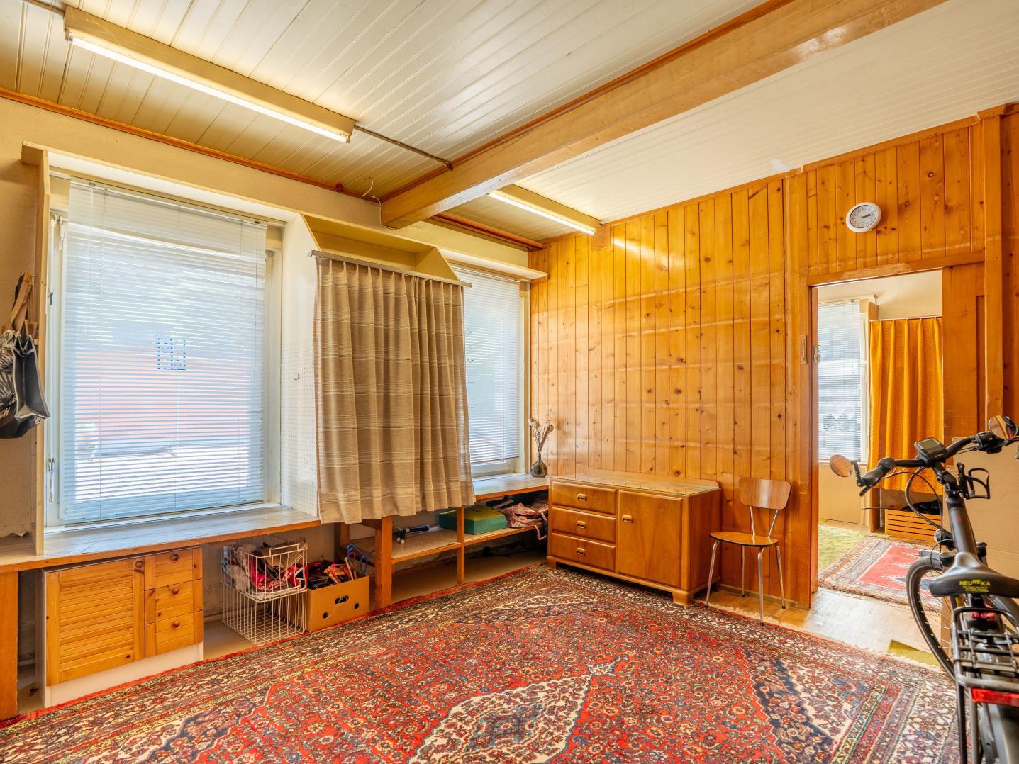 Gemütlicher, holzvertäfelter Innenraum mit Teppich und Fenstern