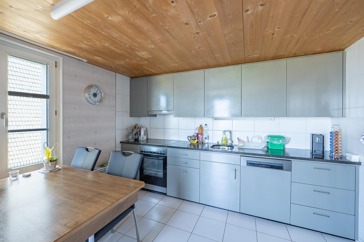 Helle Küche mit Holzdecke und Esstisch