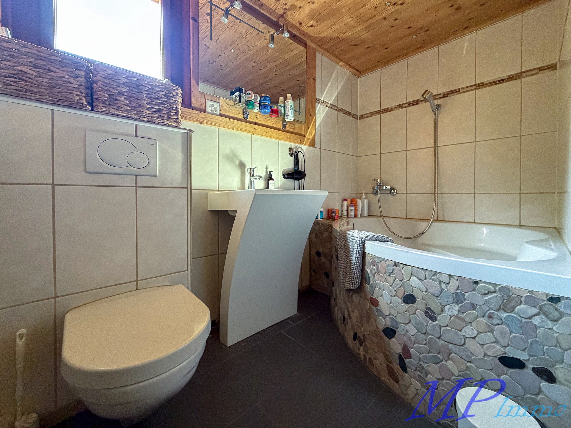 Badezimmer mit Holzdecke und Natursteinverkleidung