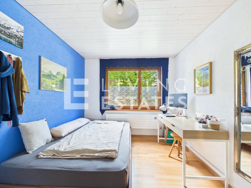 Kleines Schlafzimmer mit Schreibtisch und blauem Akzent
