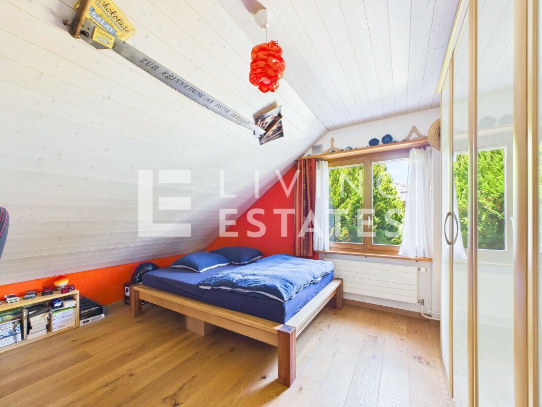 Dachgeschoss-Schlafzimmer mit Fenster und Kleiderschrank