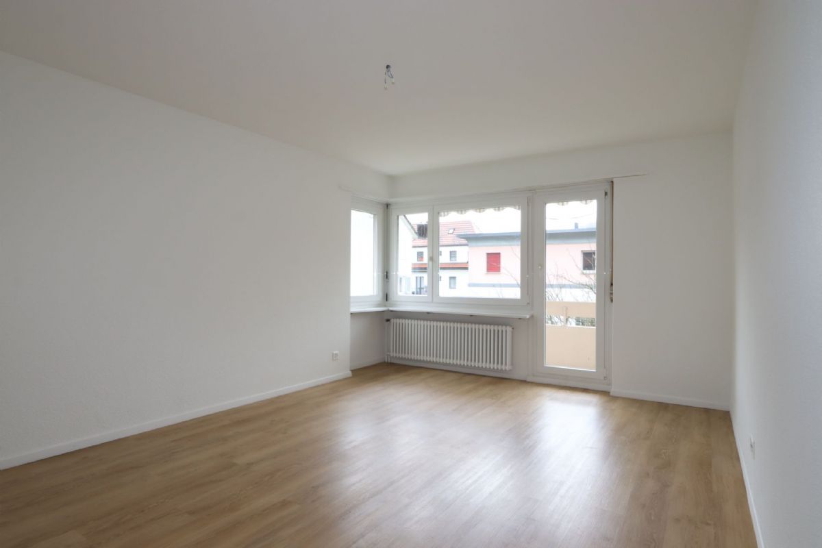 Leerer, heller Wohnraum mit Balkonfenster
