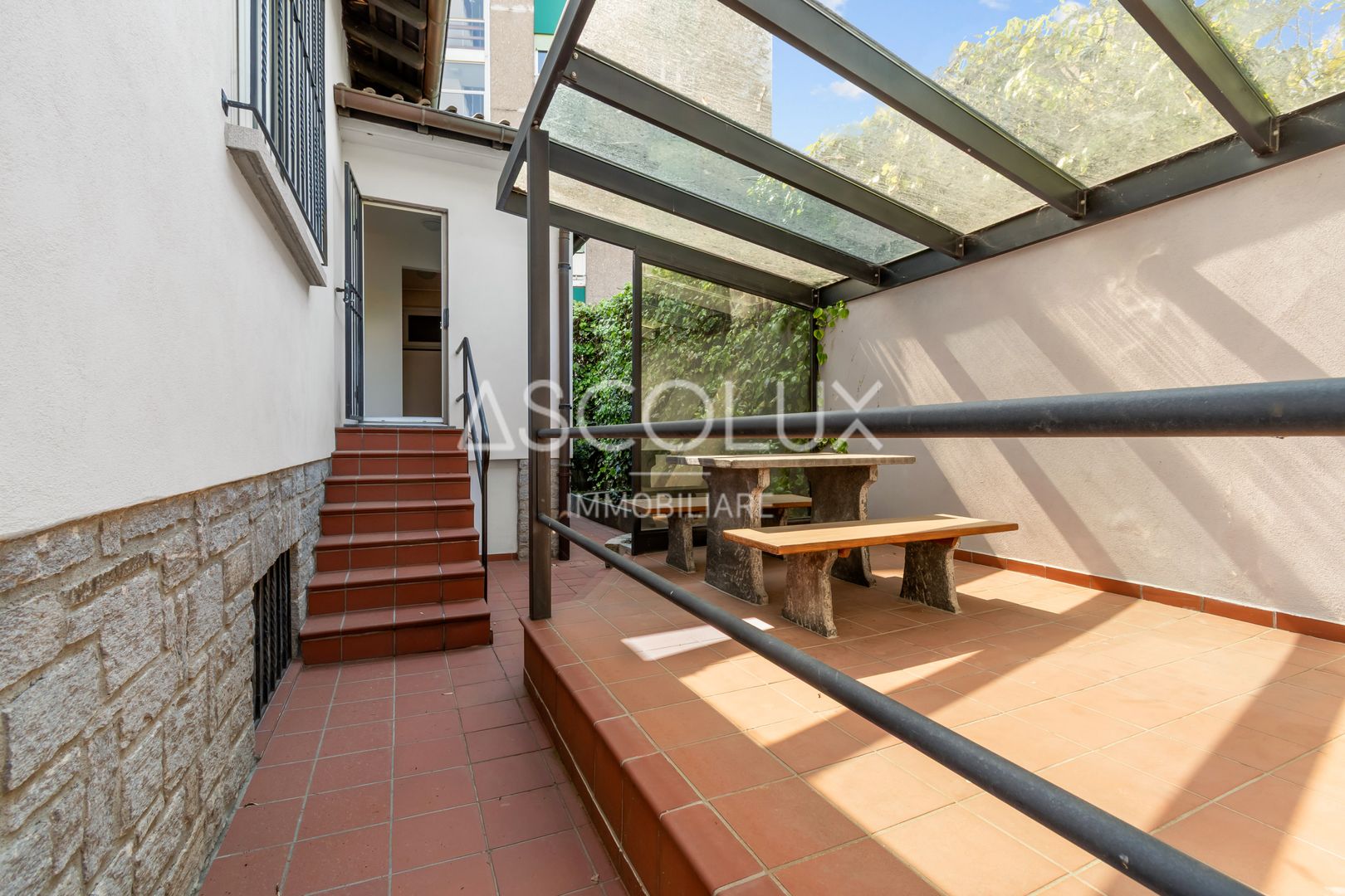 Überdachte Terrasse mit Treppe und Sitzbereich