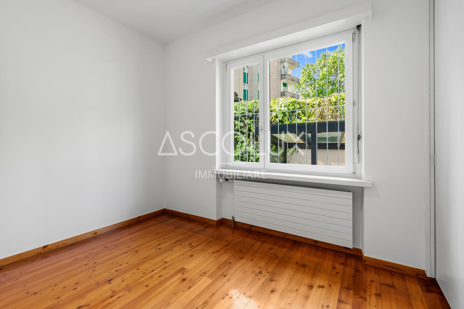 Heller leerer Raum mit Holzfußboden und Fenster
