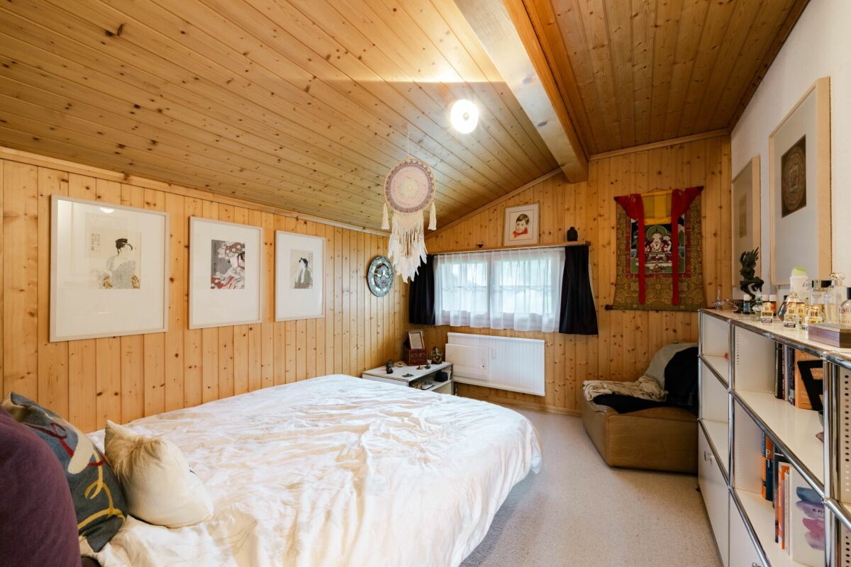 Gemütliches Schlafzimmer mit Holzverkleidung und Dachschräge