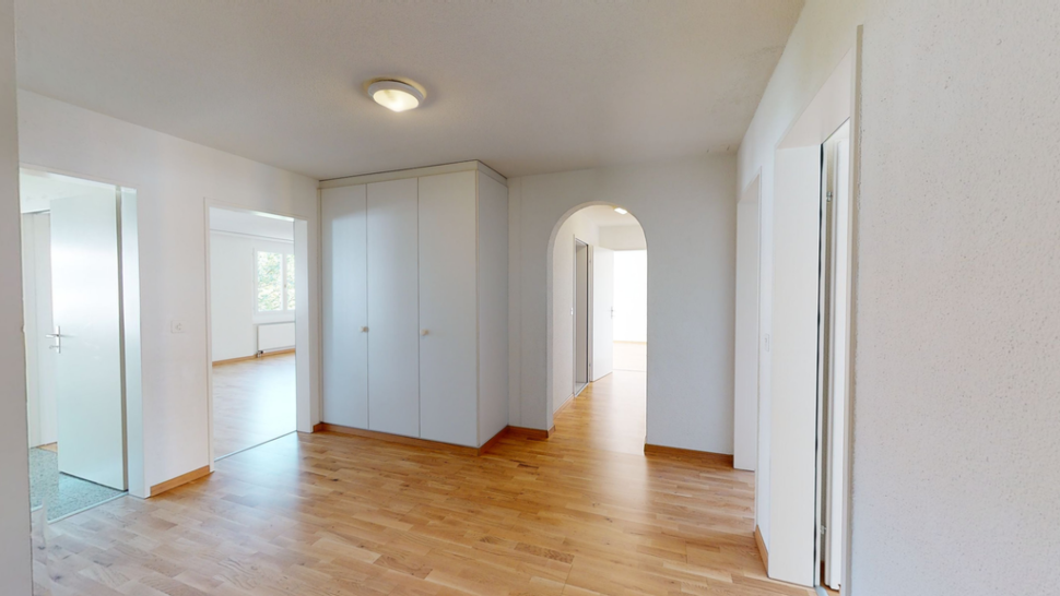 Heller Flur mit Holzboden und Durchgängen