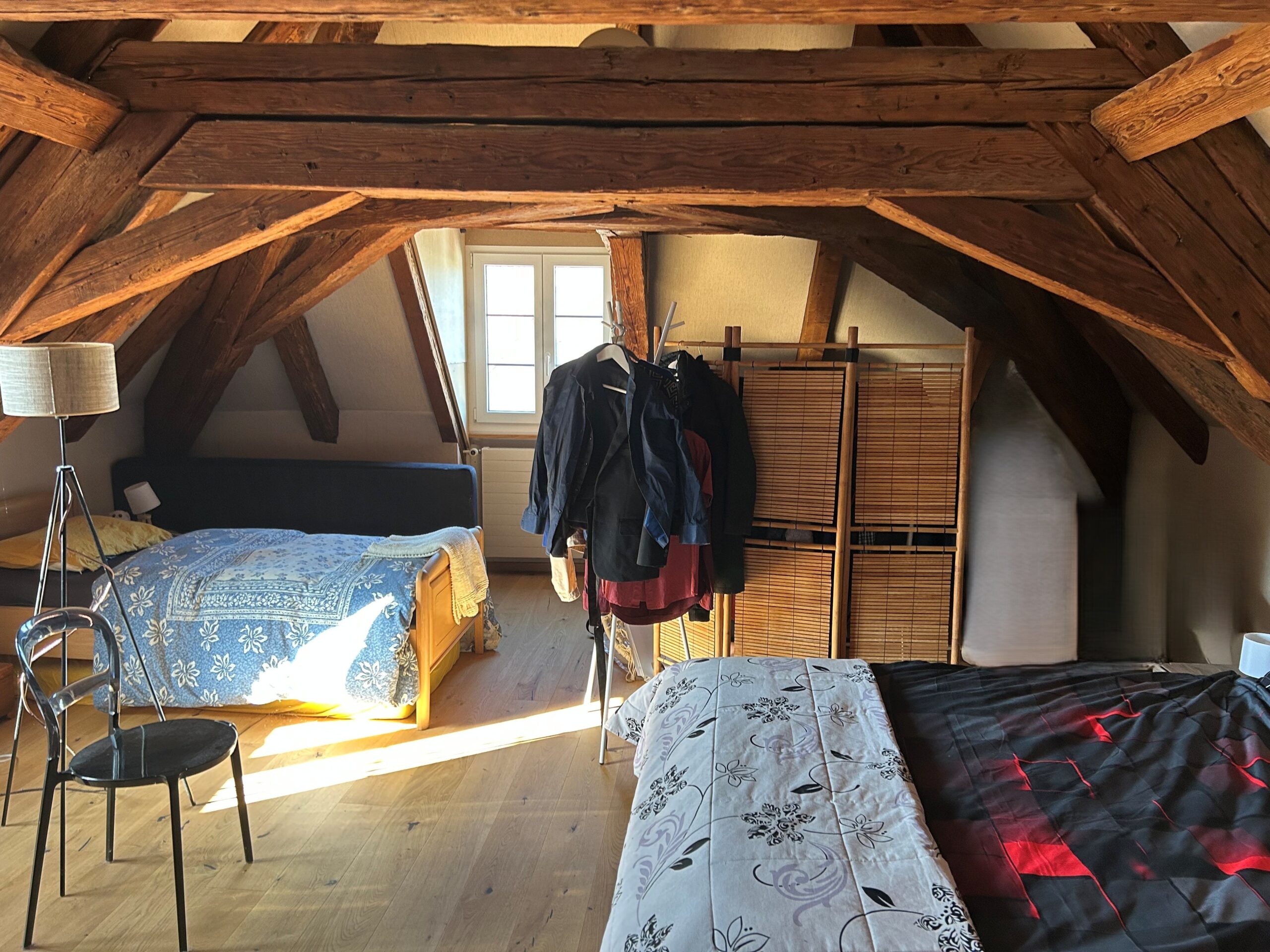 Dachgeschoss-Schlafzimmer mit sichtbaren Holzbalken