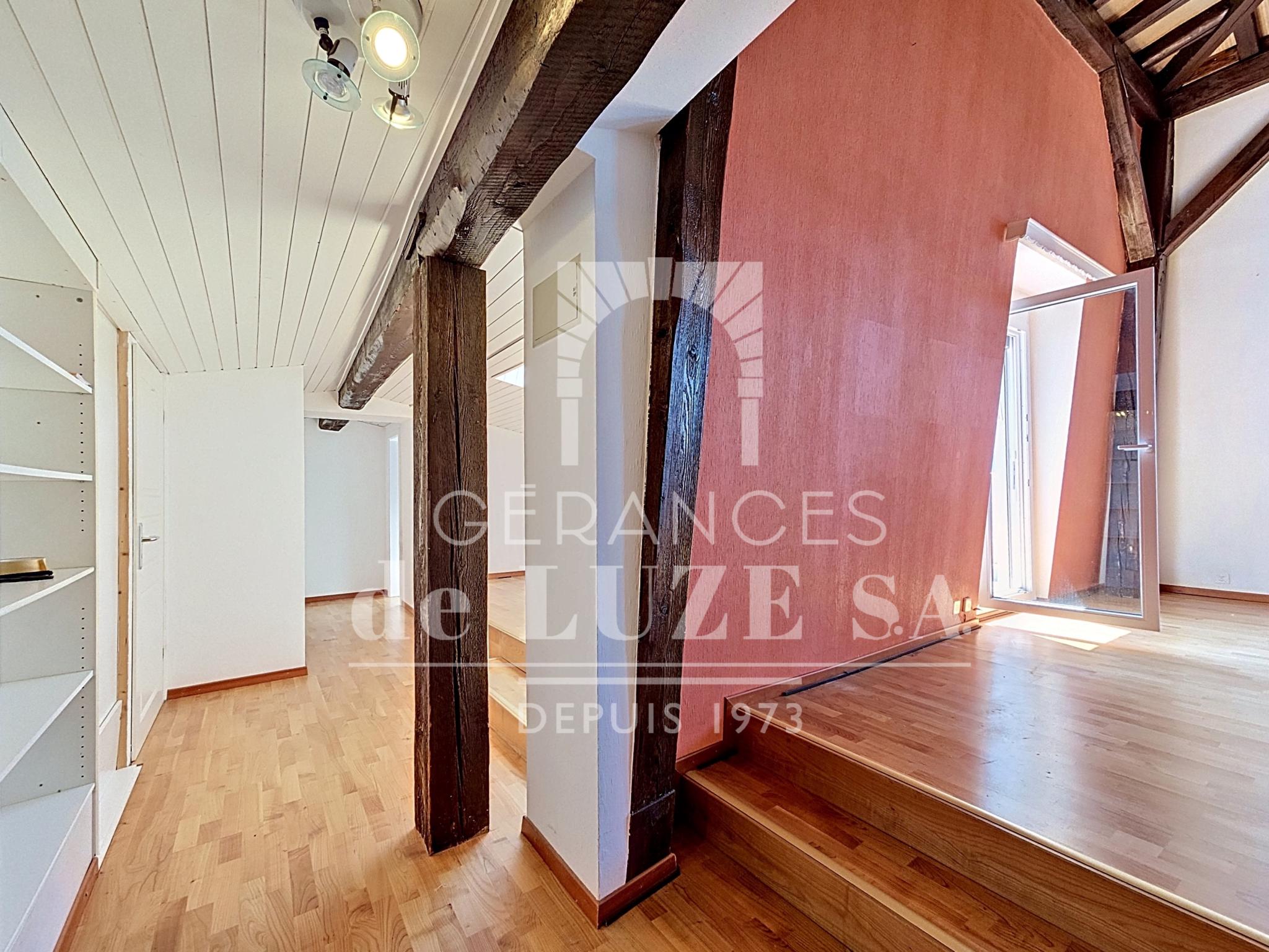 Maisonette mit sichtbaren Holzbalken und Dachschräge
