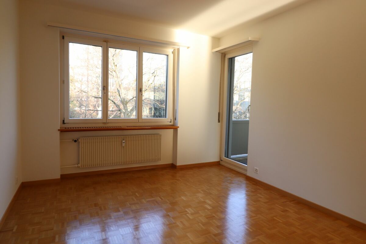 Heller leerer Wohnraum mit Balkon und großen Fenstern