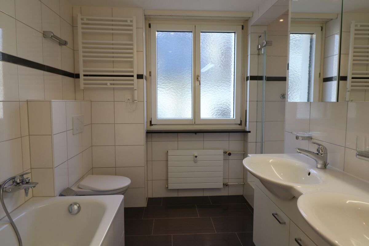 Helles Badezimmer mit Doppelwaschtisch und Badewanne