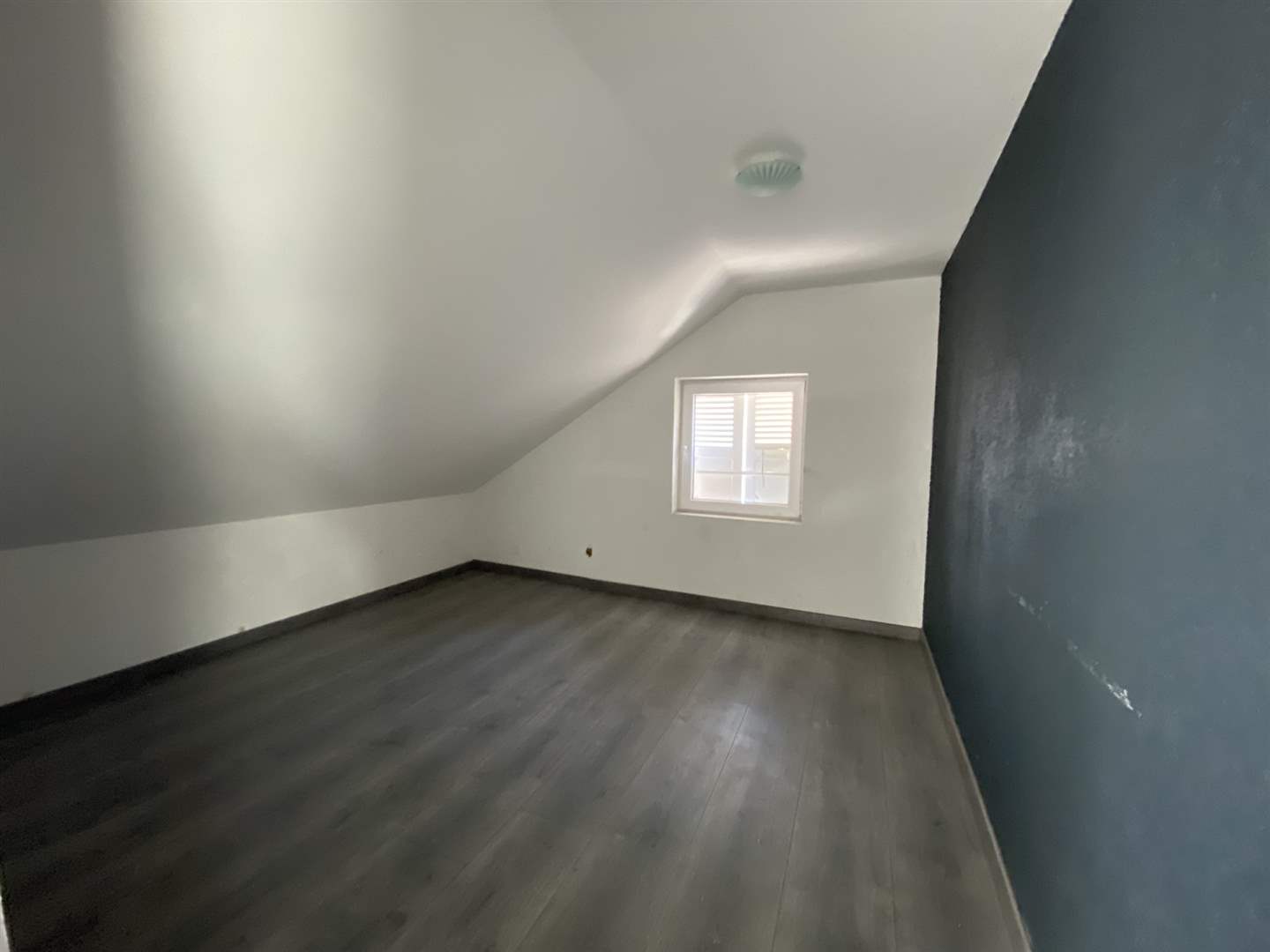 Dachgeschosszimmer mit dunklem Boden