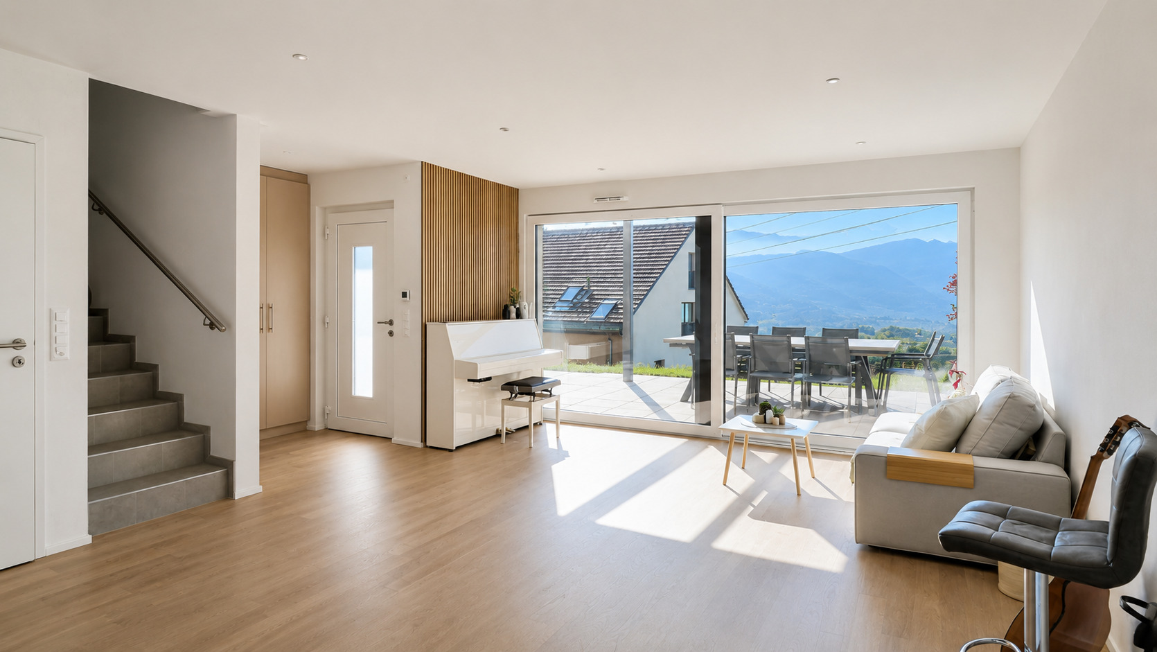 Heller Wohnraum mit großer Fensterfront und Terrasse