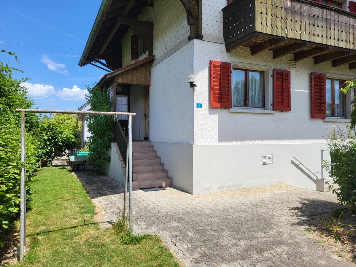 Hausfassade mit Balkon und Garten