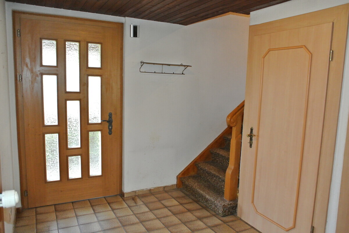 Eingangsbereich mit Holzhaustür und Treppe