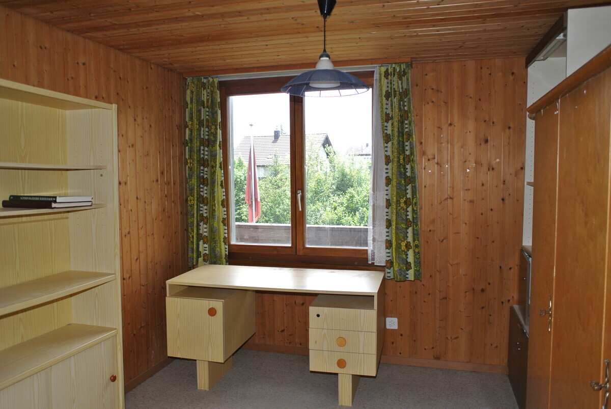 Holzverkleidetes Arbeitszimmer mit Fenster und Schreibtisch