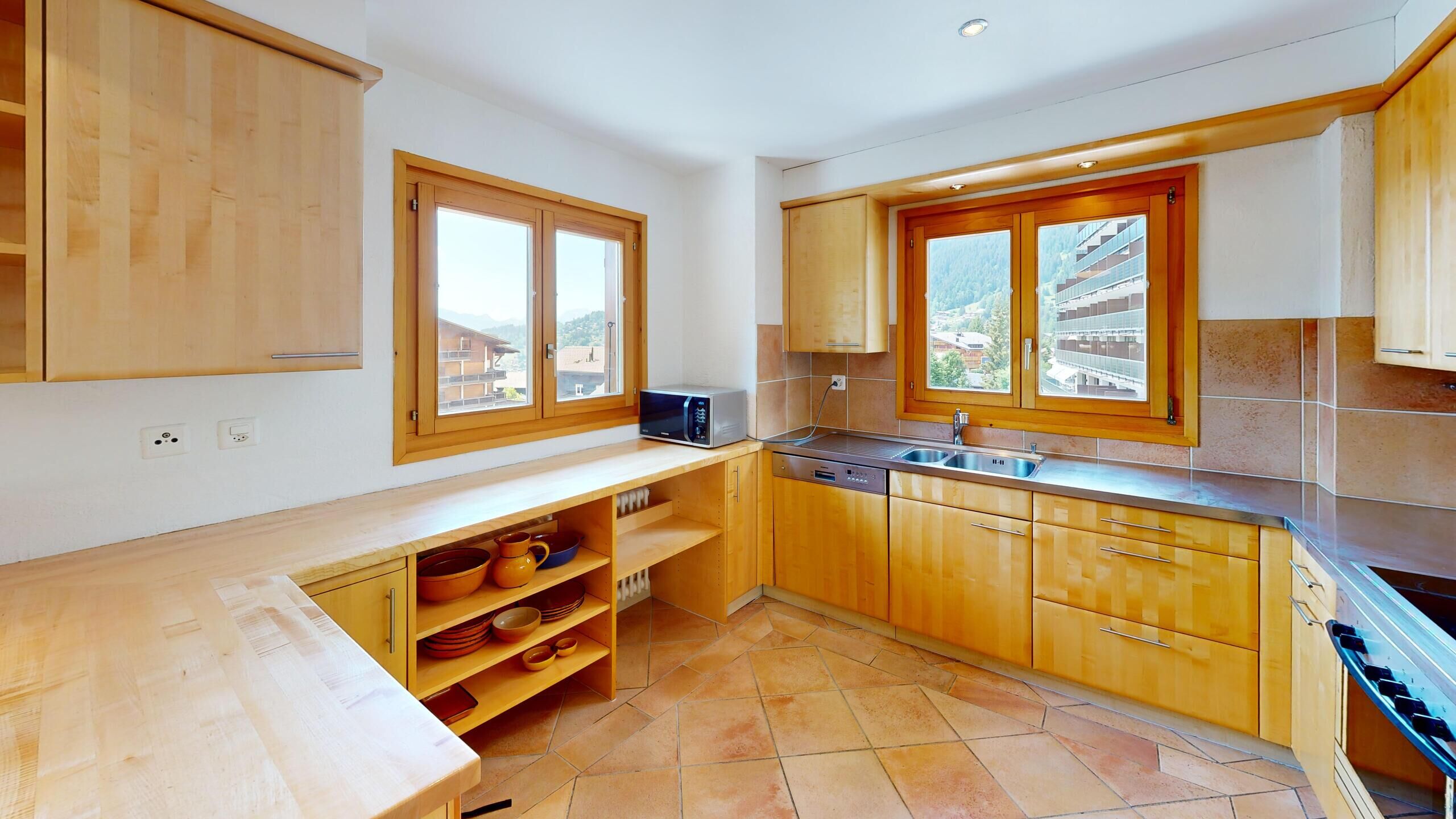 Helle Küche mit Holzmöbeln und Bergblick