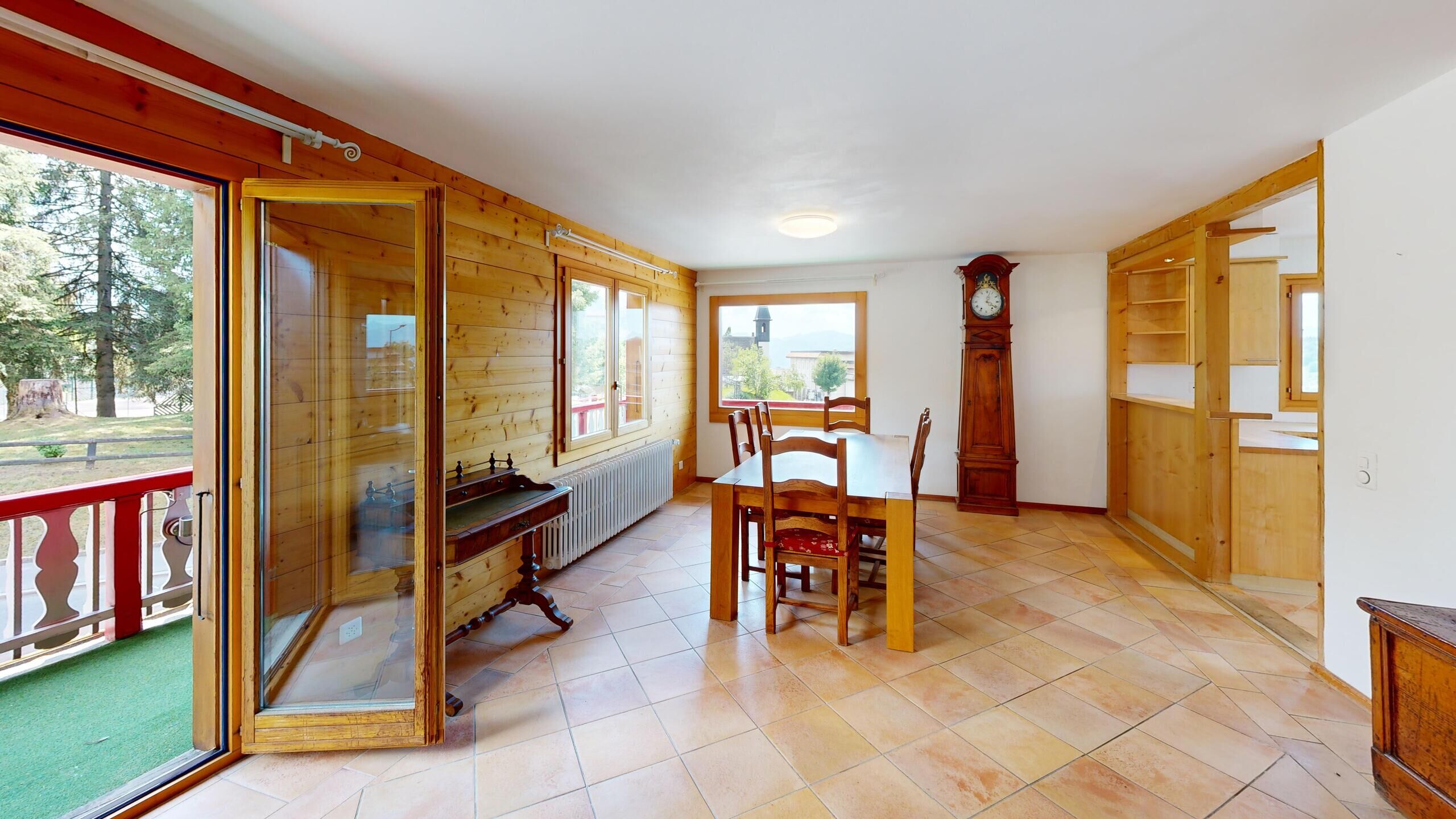 Heller Wohn-Essbereich mit Holzverkleidung und Balkon