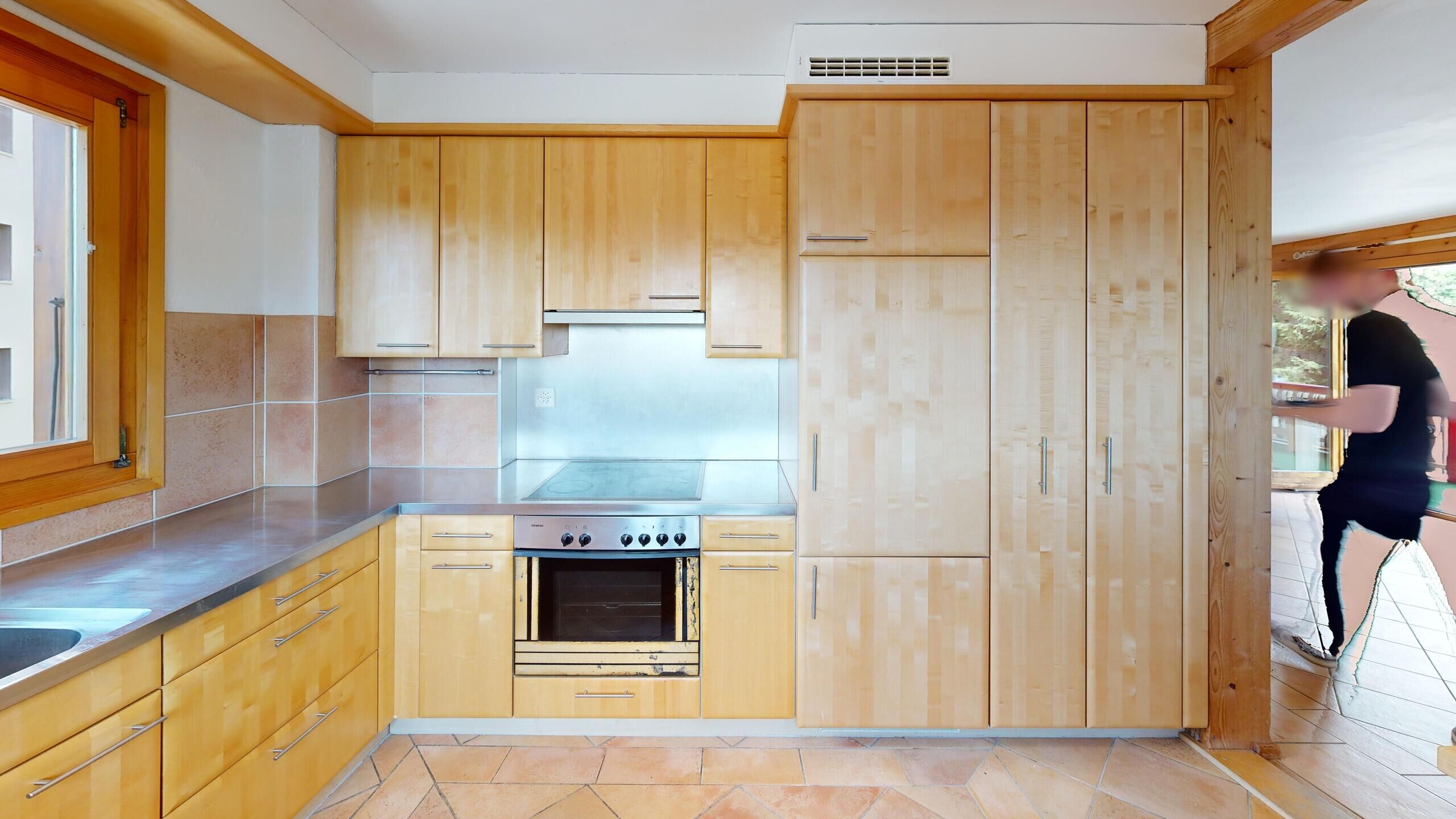 Küche mit Holzfronten und Fliesenboden