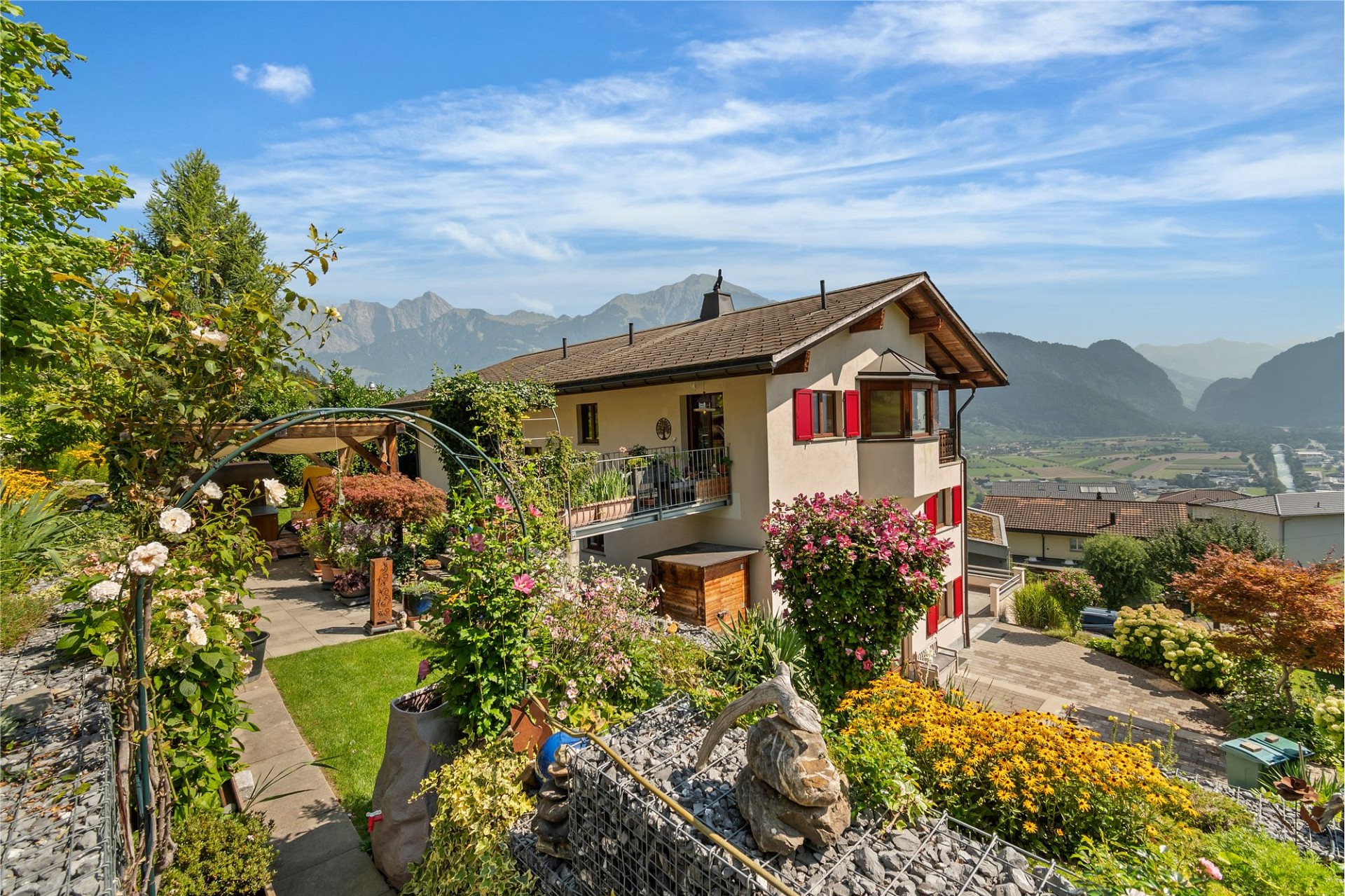 Alpenhaus mit üppigem Garten und Bergpanorama