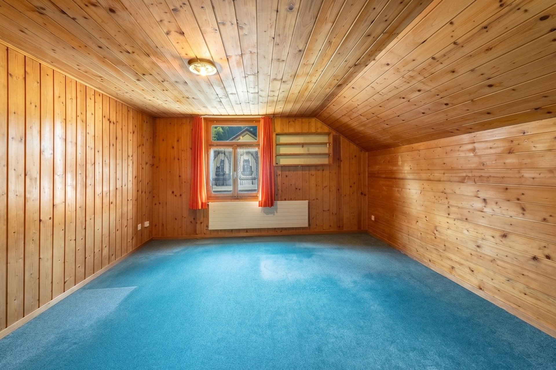 Holzvertäpelter Raum mit Dachschräge