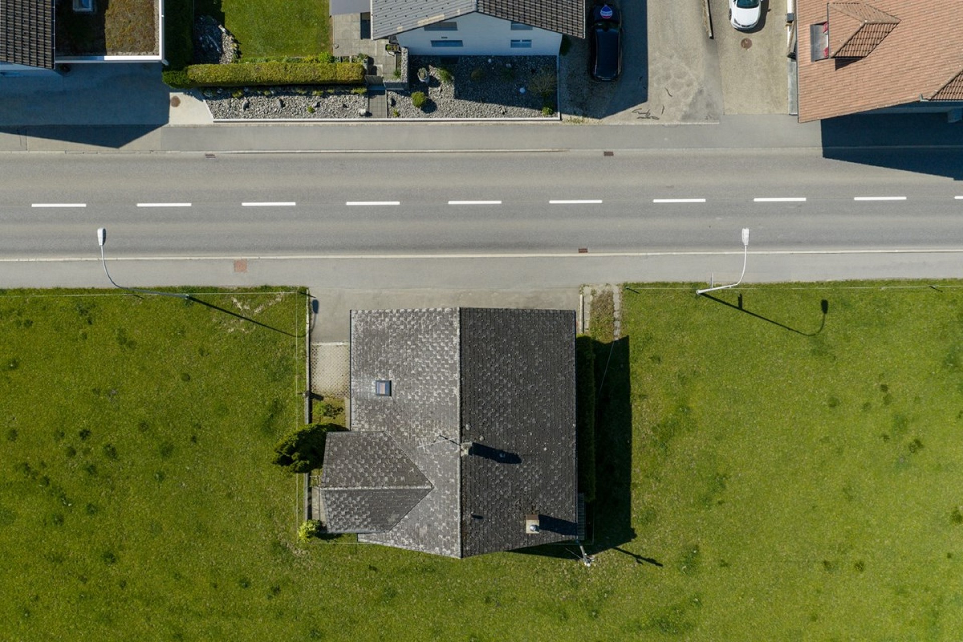 Luftaufnahme eines freistehenden Hauses am Straßenrand
