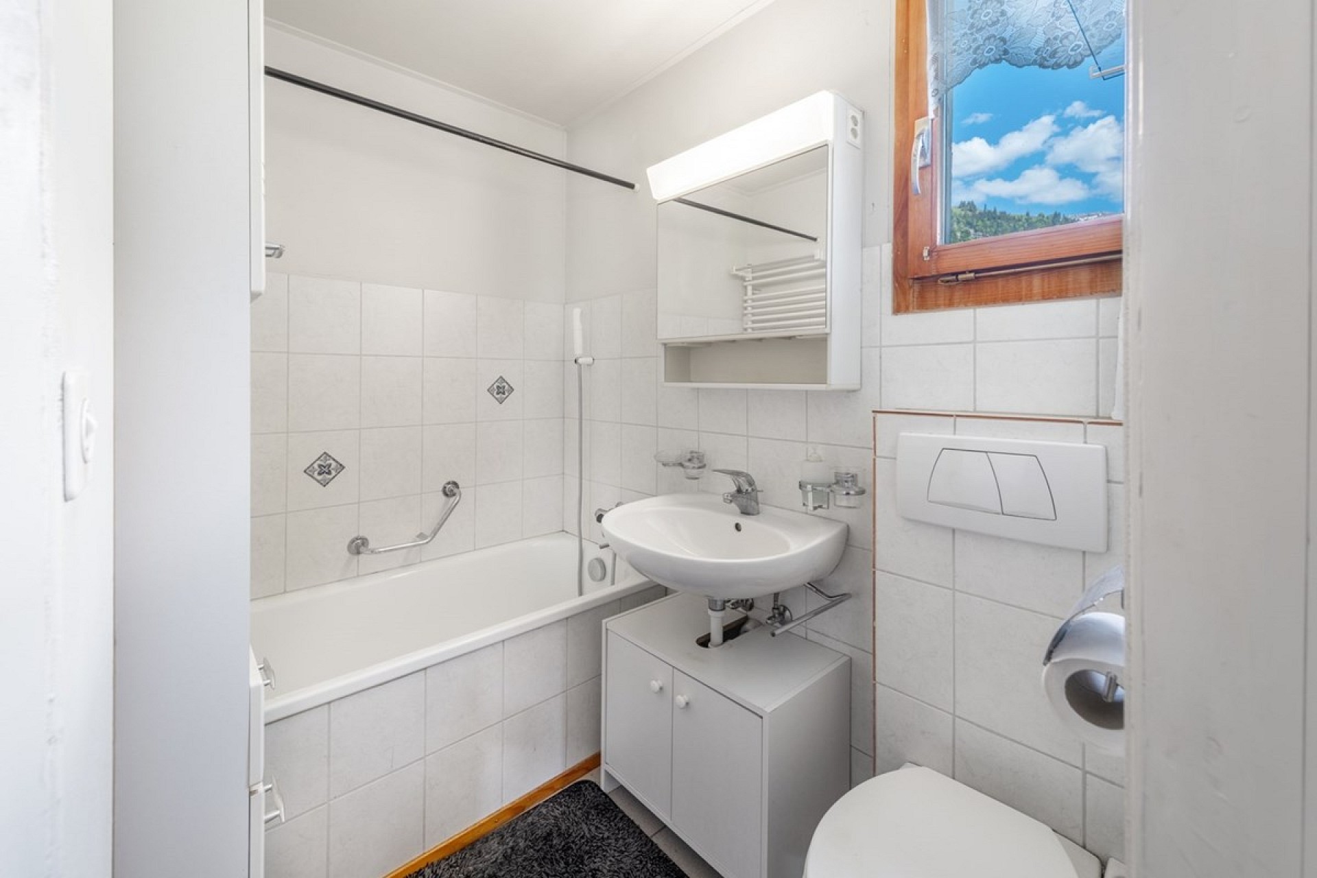 Kleines Badezimmer mit Badewanne und Waschbecken